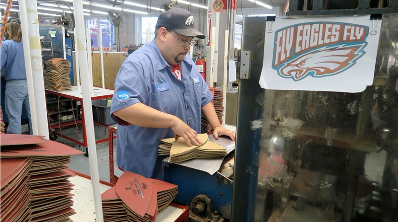 Frank Guerra, a Wilson Football Factory employee, at his stamping station. This machine prints logos on each leather panel through a 14-step stamping process.