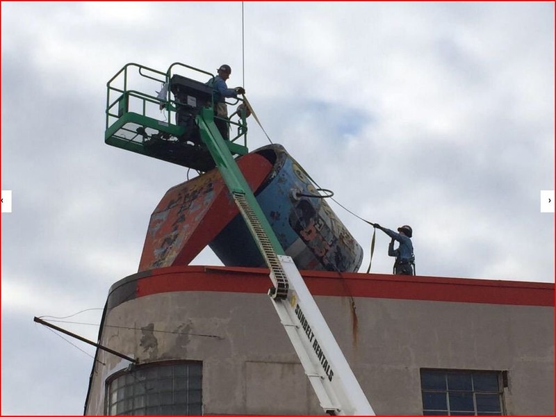 Removing the beloved paint can from the roof of Evans Lumber in 2015. The can is now in the possession of the City of South Charleston.