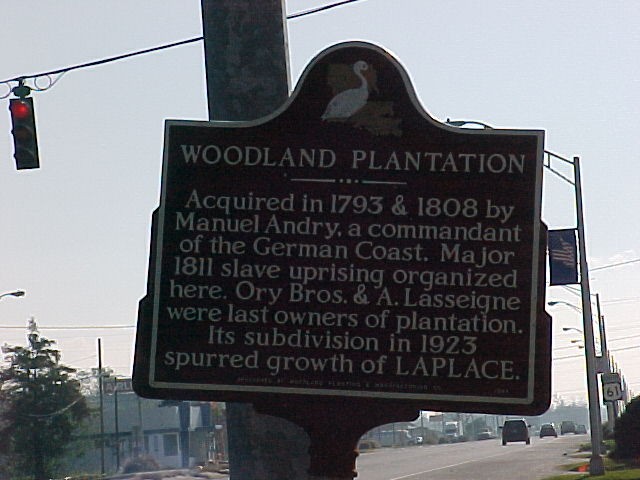 Historical marker for the Woodland Plantation that mentions slave revolt in one line that reads "Major 1811 slave uprising organized here."