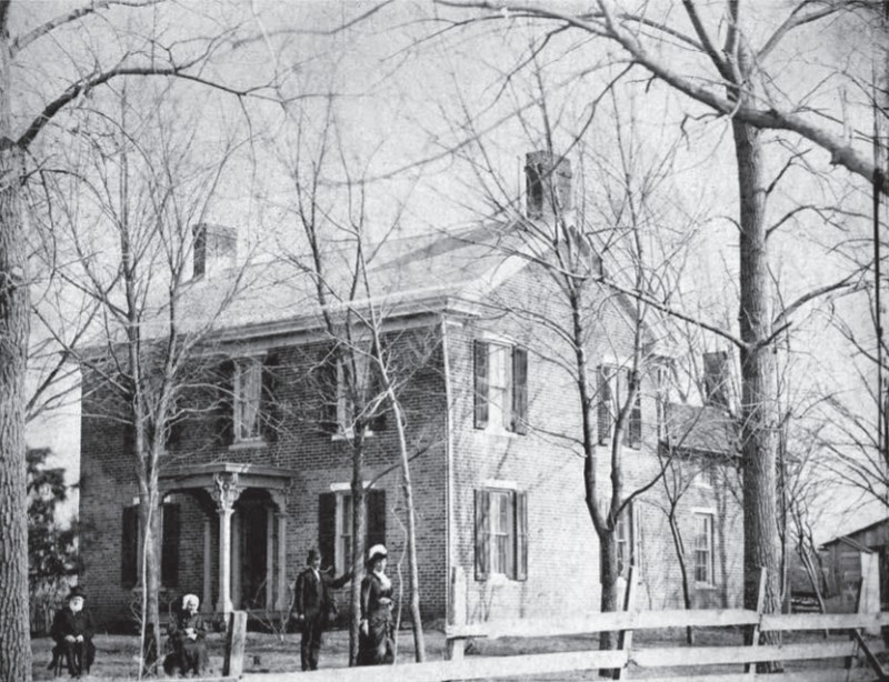 Robert Miller and his wife sit outside the house in 1881.