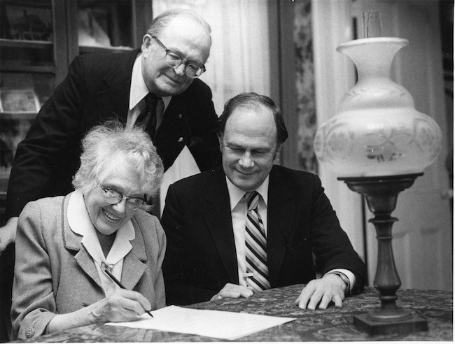 Alice Whittier signs the deed donating the Skolfield-Whittier House to the Pejepscot Historical Society in 1982. On the right are Orville Ranger, the lawyer, and Bert Whitman, the representative for the Society.