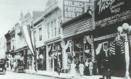 Milnes-Friend grocery occupies 110 East Fourth in this photograph, c.1915. Also visible in this image are the buildings at 100 and 106 East Fourth Street.