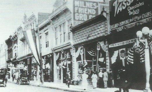 Milnes-Friend grocery occupies 110 East Fourth in this photograph, c.1915. Also visible in this image are the buildings at 100 and 106 East Fourth Street. 