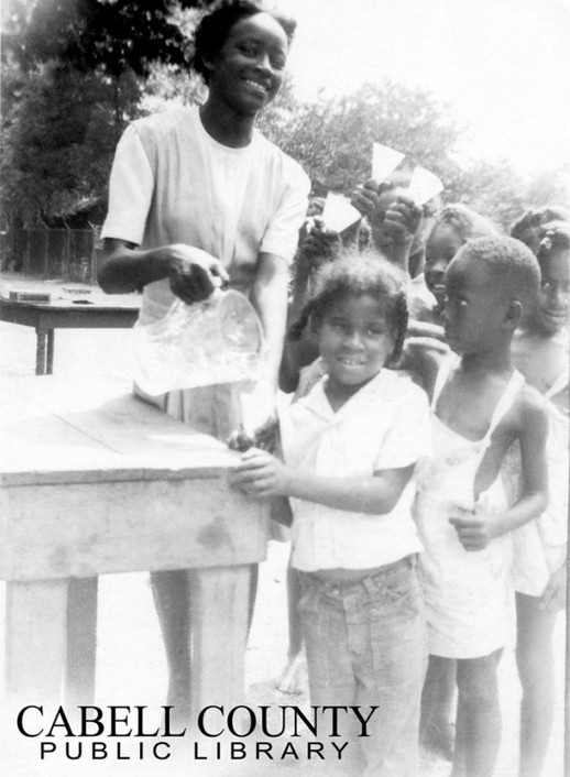 Children and a teacher at the Barnett School playground