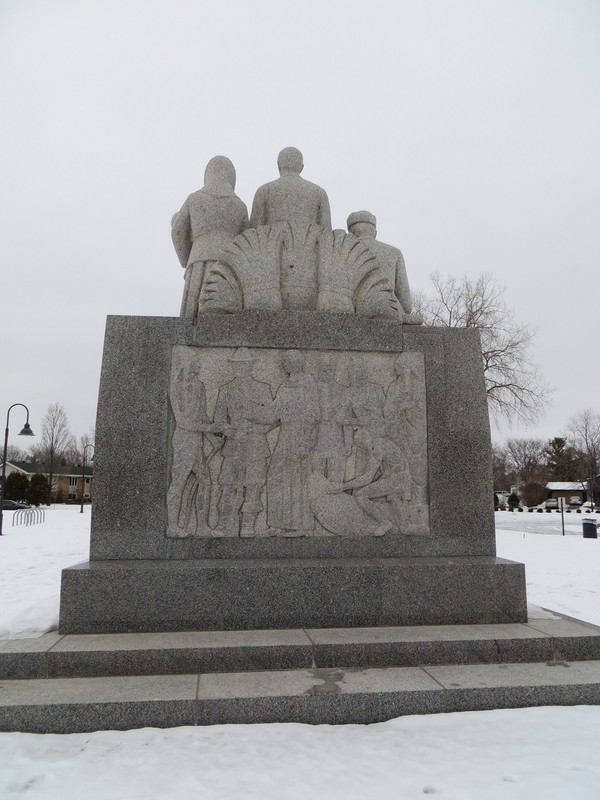 Relief sculpture of Louis Hennepin sharing peace pipe with Native leaders.