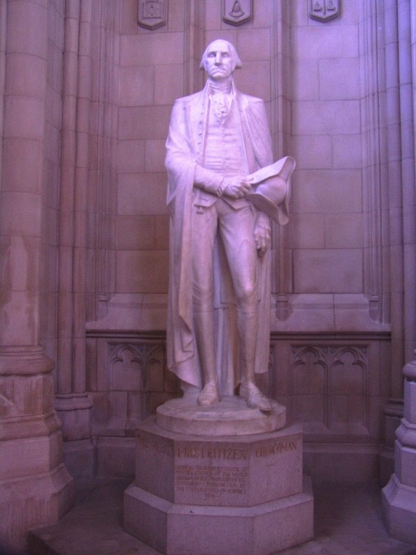 A statue of President George Washington, who planned the Cathedral, stands in an alcove where symbols such as his coat of arms can be found. Photo by Danvera, English Wikimedia. 