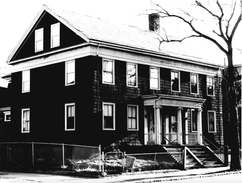 Black and white photo of a wood-panelled house