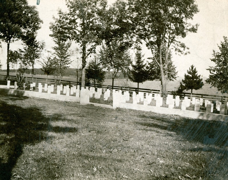 Photograph of Confederate Rest, Forest Hill Cemetery, Madison, Wisconsin. Featured is the stone fence around the graves, the grave markers and a memorial stone with the names of all of those buried there, including Alice Whiting Waterman.  