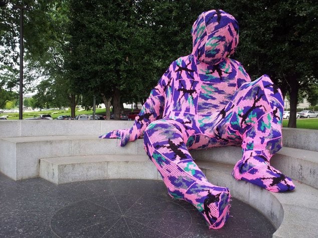 Guerilla crochet artist, Olek covers that statue in pink and purple fabric.