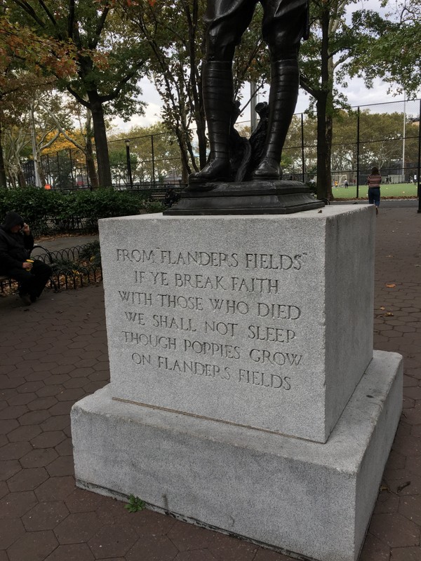 The inscription at the base of the front of the statue. An excerpt of the poem, "In Flanders Fields."