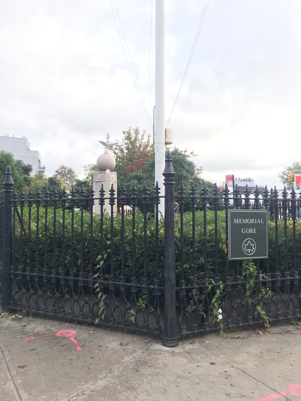 The monument behind the gates of the park.