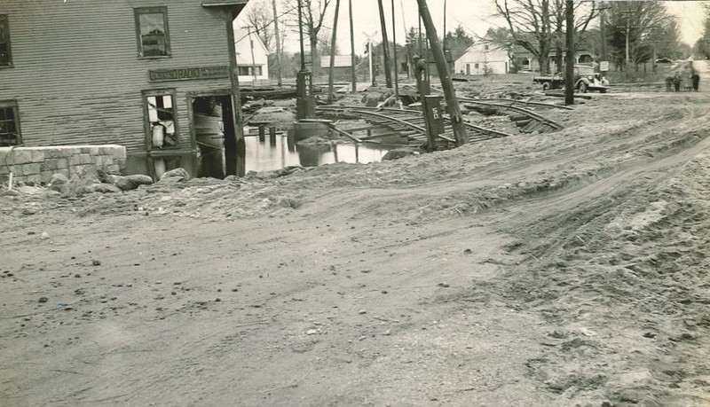 One of the businesses which suffered extensive damage from the flood of 1936 was the Nelson Grain Mill, which was sheared in half. Also visible in the photos is the damage to the railroad tracks. 