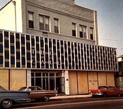 A picture of the store front accompanied by some classic cars