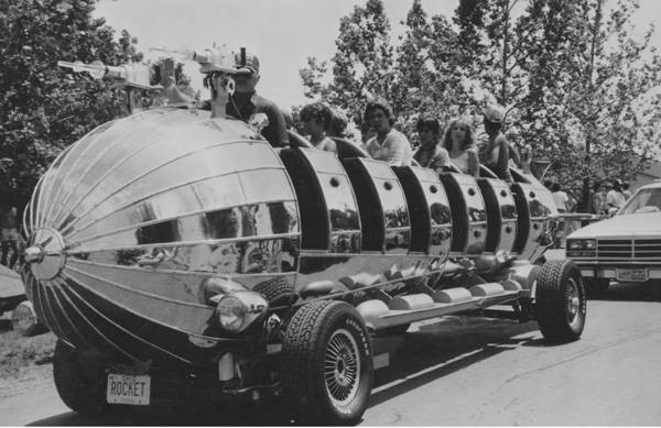 Park-goers riding a large rocket-like vehicle at Euclid Beach Park (black and white)