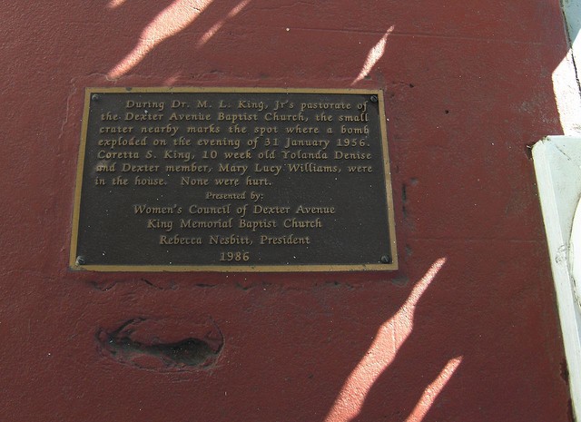 A plaque and the leftover damage from one of the bombs after reconstruction.