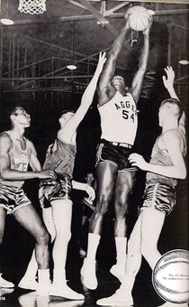A black and white photo of a basketball player shooting a hoop.