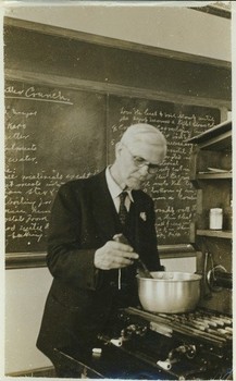 Walter W. Chenoweth stirring a pot on stove, in laboratory, ca. 1941. 

