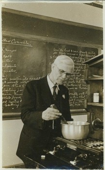 Walter W. Chenoweth stirring a pot on stove, in laboratory, ca. 1941.