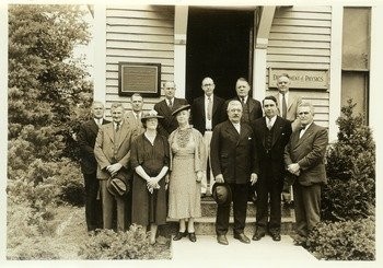 Hugh P. Baker (President, 1933-1947) standing with others in front of the Botanical Museum plaque, photo, ca. 1935.