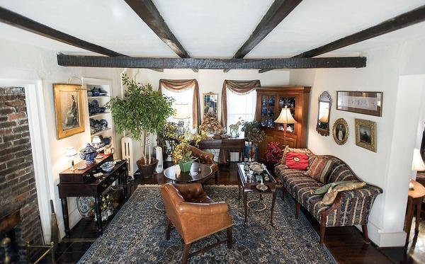 The living room of the house features exposed brick surrounding the fireplace, exposed wooden beams, and built-in shelves. (Stephen Haas, for The News-Gazette)