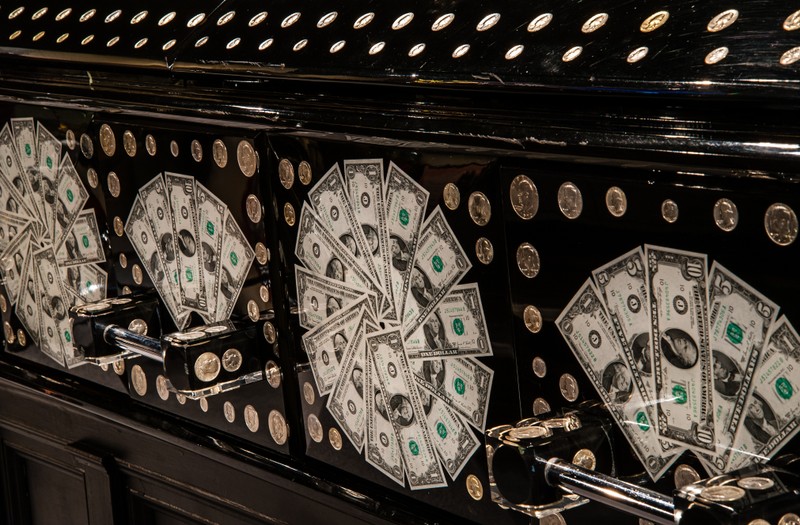 One of the more unique caskets on display is this one embedded with money. Image courtesy of the National Museum of Funeral History. 