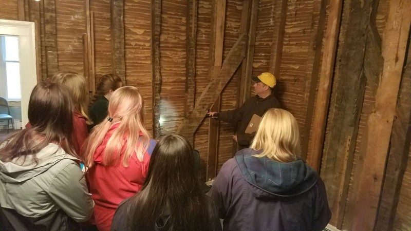 Liberty University history students viewing original architectural work inside Mead's Tavern.