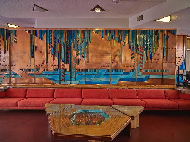 A hotel lobby with metal artwork on the walls.