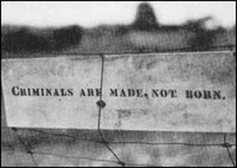 A sign left by Kehoe on the fence of his firebombed farm reads "Criminals are made, not born"