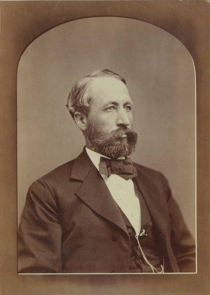 William S. Clark, ca. 1876. Formal portrait with bow tie and watch fob. Photo mounted on white cabinet card with name of photo studio at the bottom.