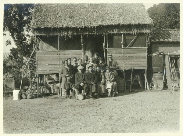 Kenyon L. Butterfield, 1913. Group portrait commemorating a visit to South China in late Fall 1913. President Butterfield and his wife, who are seated in the front row of the picture, have been visiting a farmer who raises delicious loose-skinned ora