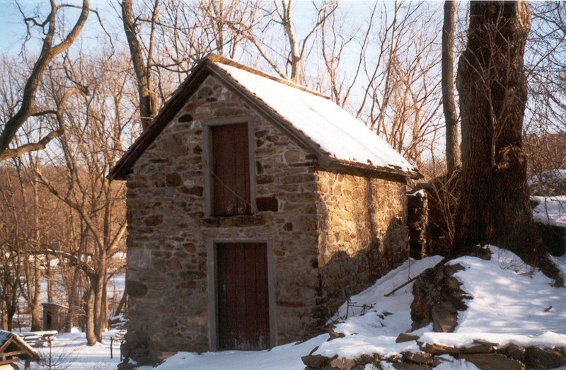 Image of small 2-story outbuilding with a door on each level.