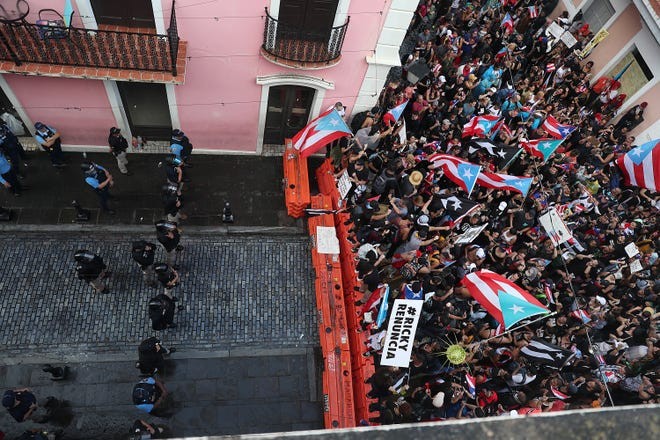 Protesters taking over "La Calle Fortaleza" and being stopped by a police barricade outside the governor's official residence