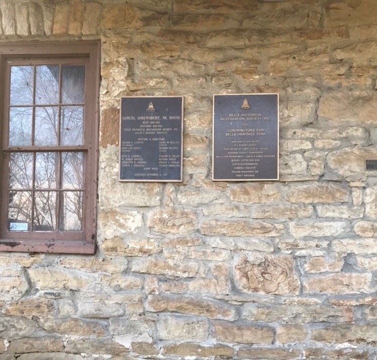 The brass plaques on front porch inscribed with the names and dates of the house dedication ceremony.