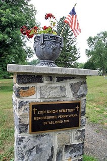 Pillar with plaque marking the cemetery, established in 1876. 