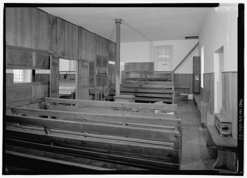 The simple interior of the meetinghouse is usual among the Society of Friends. 