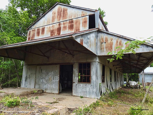 A current photo of a rusted out older building.