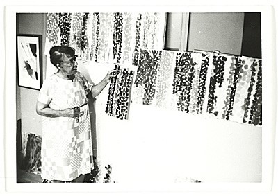 Alma Thomas standing in front of her own artwork in her kitchen studio