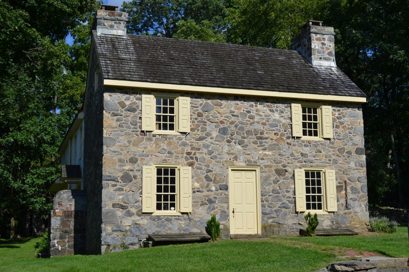 Image of the front facade of the 2-story stone house.