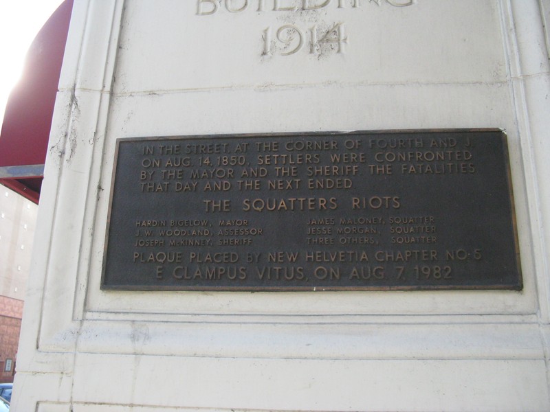 The 1982 commemorative plaque placed on the NE corner of the California Fruit Building, near where the line of squatters made their stand. The listed dead did not all perish in this gunfight (photo by Syd Whittle, hmdb.org).