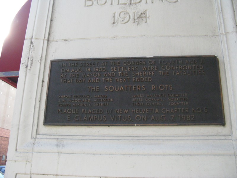 The 1982 commemorative plaque placed on the NE corner of the California Fruit Building, near where the line of squatters made their stand. The listed dead did not all perish in this gunfight (photo by Syd Whittle, hmdb.org). 