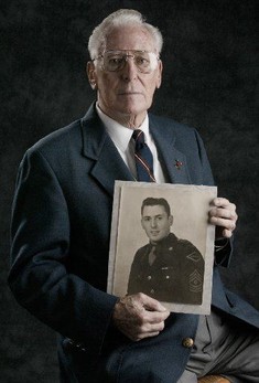 Leonard Lomell pictured with his military photo from World War II.