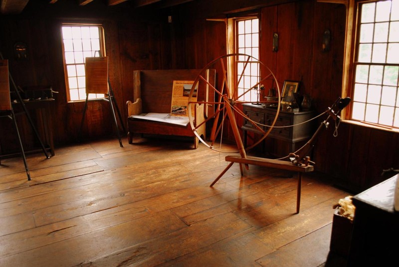 A spinning wheel sits in one of the rooms within Smith's Castle.