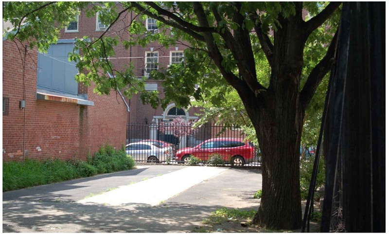 Photograph of the iron perimeter fence, constructed in the 1920s, and the recreational building, built in the 1970s.