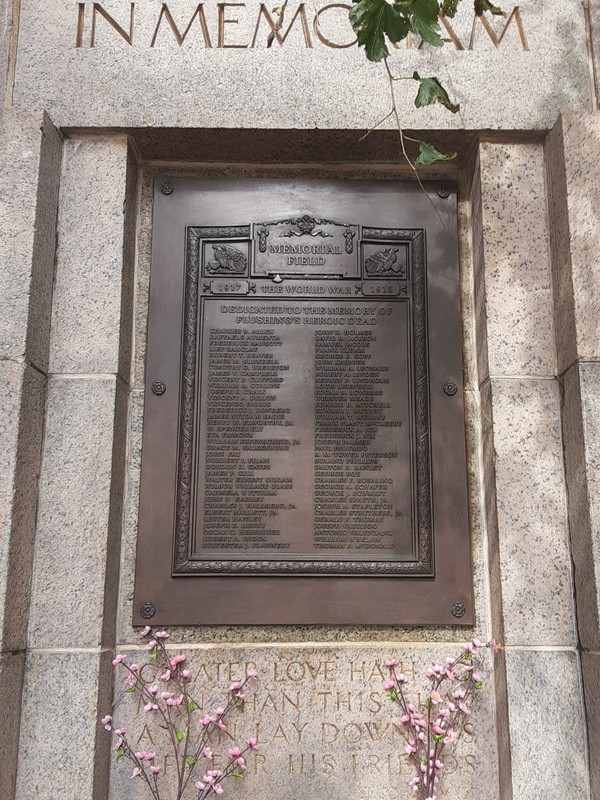 The bronze plaque, with 70 names inscribed. The top reads "In Memoriam"