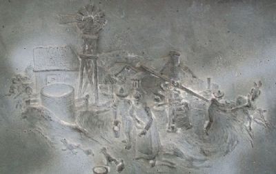 Scene in metal above inscription. Men and women do farm work, including sowing seeds and plowing. A house and windmill are in the background.