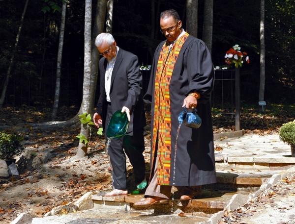 Two of the ministers who dedicated the cemetery. They are pouring water from the New River on the ground.