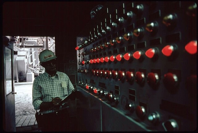 A worker in the "baghouse" control room circa 1975. Baghouses came into widespread use to control air pollution at power plants and factories in the late 1970s, and use a variety of methods to trap fine particulates from escaping the plant.