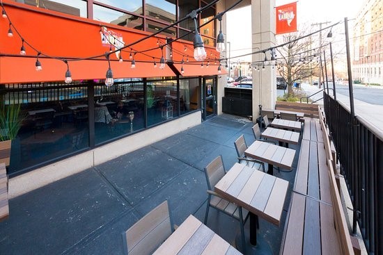 The outside of Esquina Latina, showcasing the outdoor seating provided to customers and the street accessibility. 