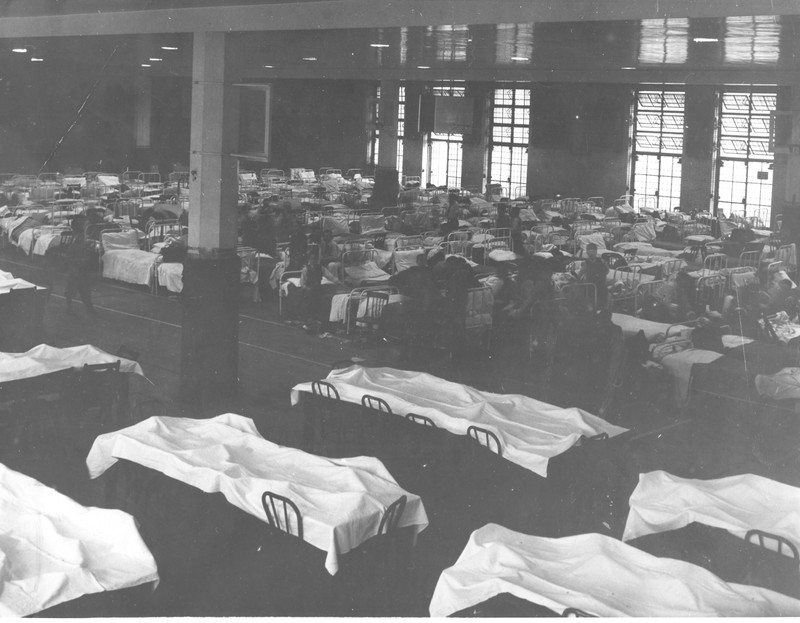 1939 photo of empty dining area and students in bed area while quarantining in Armory during scarlet fever epidemic. 