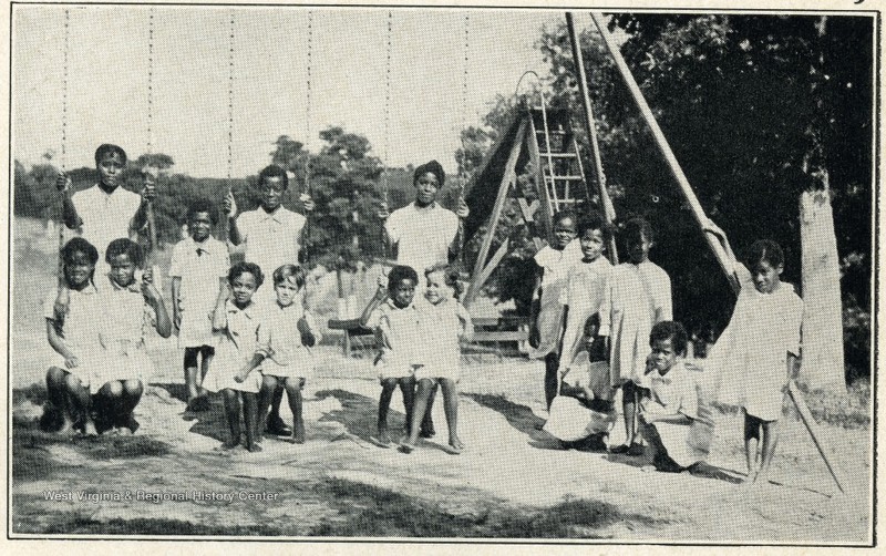 Children of the West Virginia Colored Orphan's Home playing on a swingset